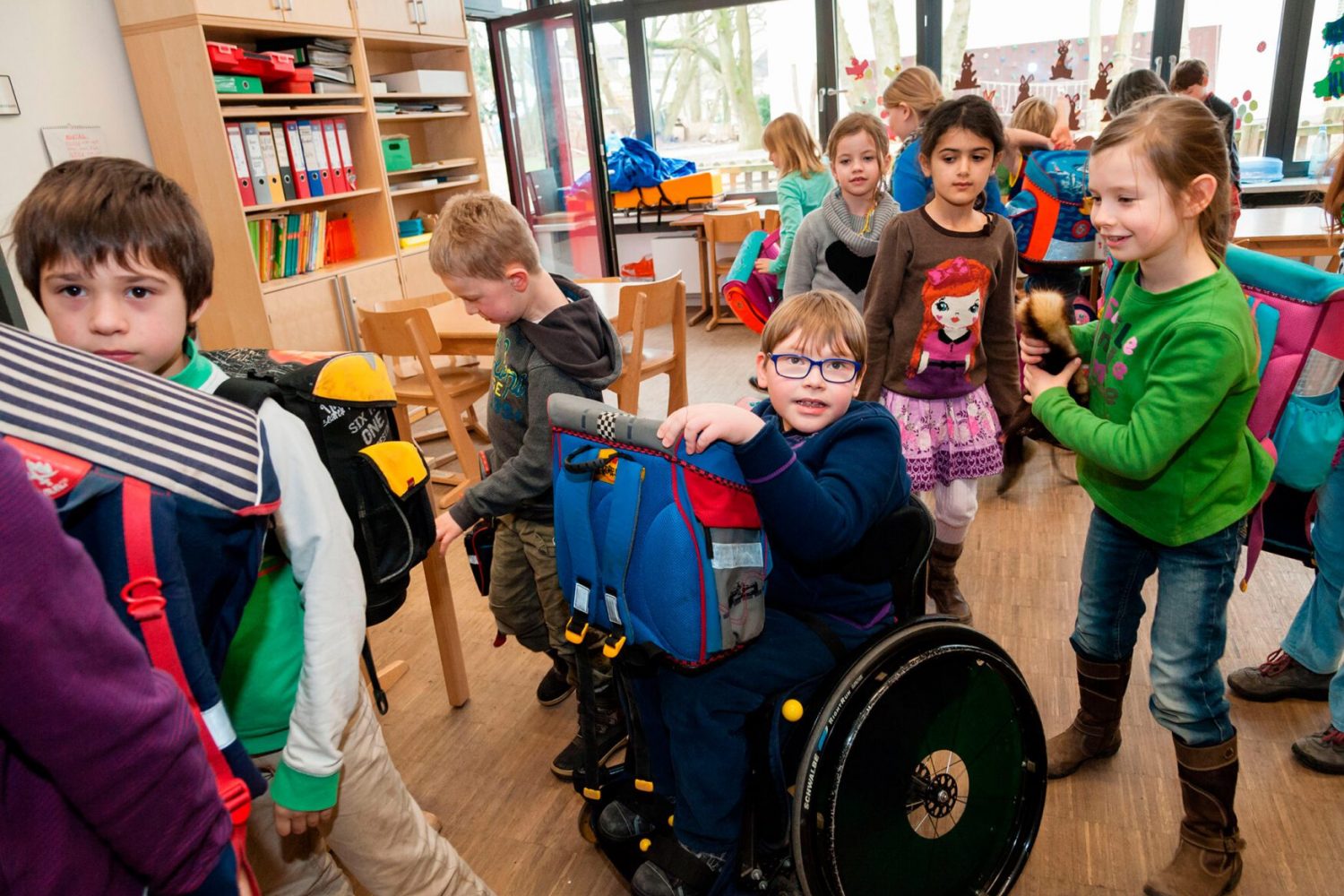 DY9JF3 Non-disabled and disabled students (in this case a boy in a wheel chair) learn together in the same class in a primary school.